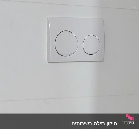 לחצן הדחה כפול על קיר לבן